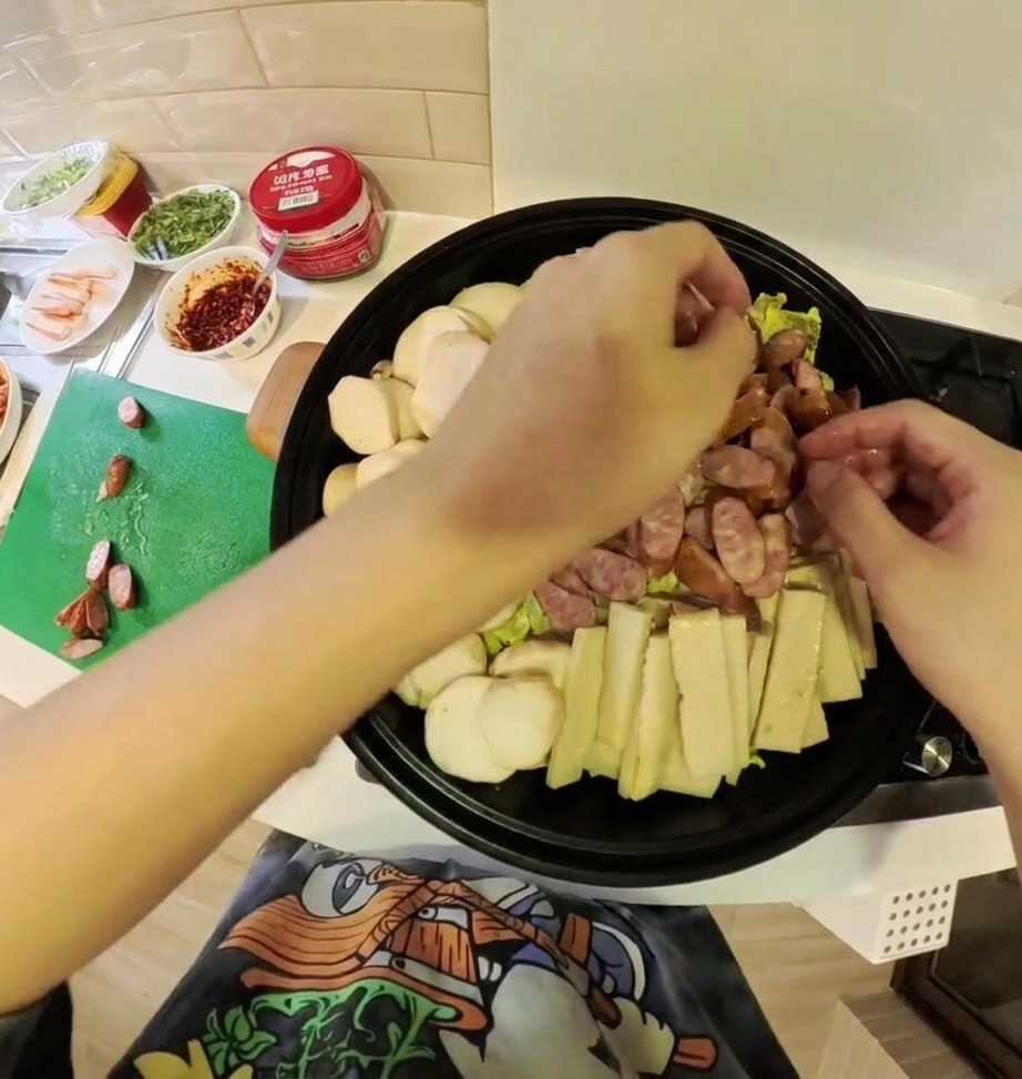 Une variété dingrédients de ragoût coréen, dont le kimchi, la viande et les légumes, joliment disposés dans une marmite peu profonde.