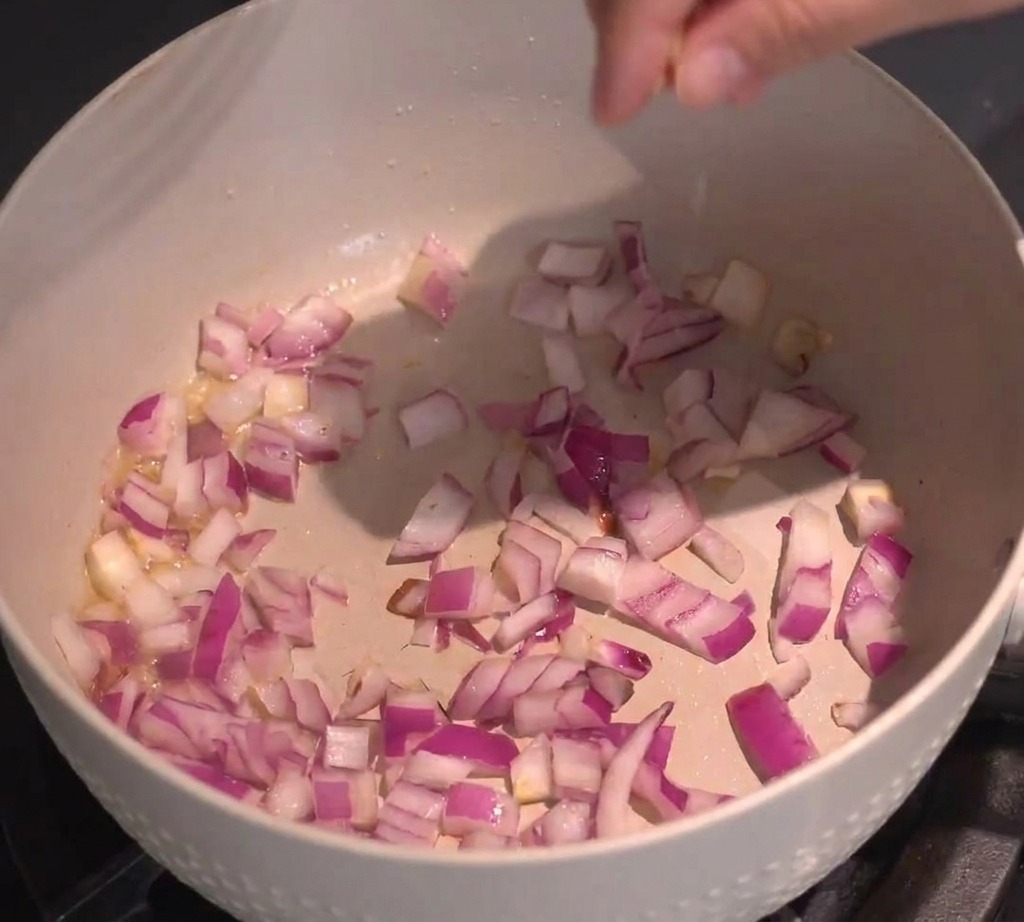 Dés doignons rouges sautés dans une poêle claire sur la cuisinière.