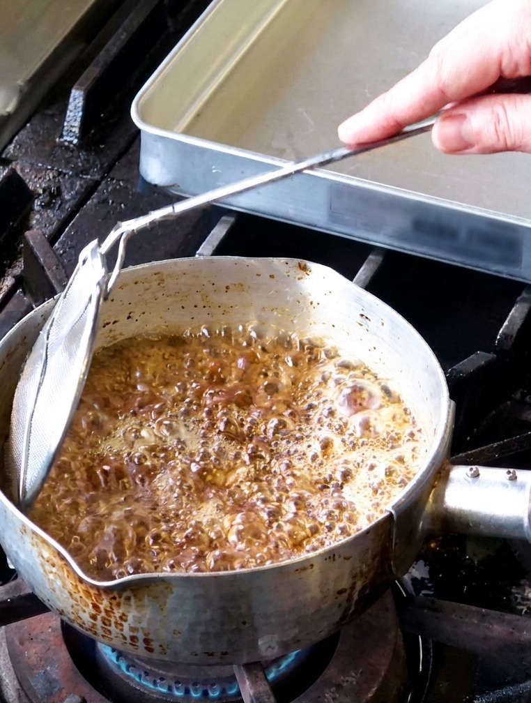 Tranches dail frites dans une casserole dhuile bouillonnant vigoureusement avec de la vapeur séchappant de la surface.