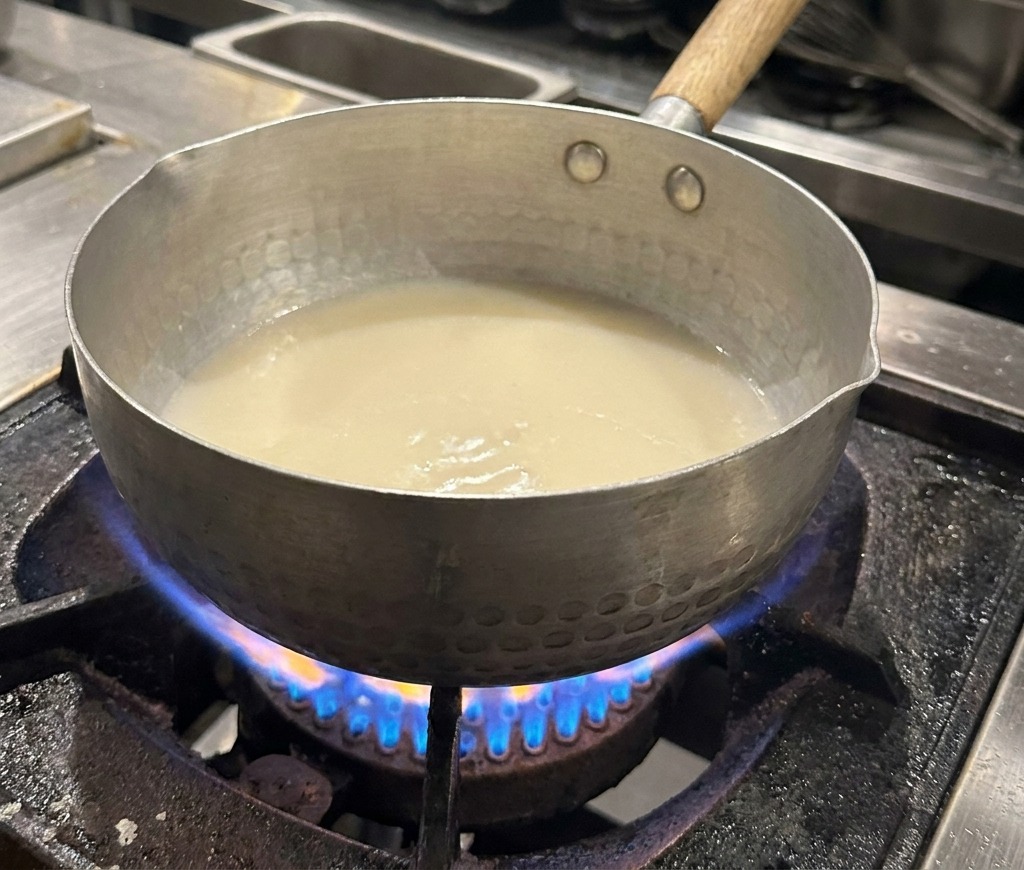 Gros plan sur un bouillon blanc avec des gouttelettes dhuile scintillantes à la surface.