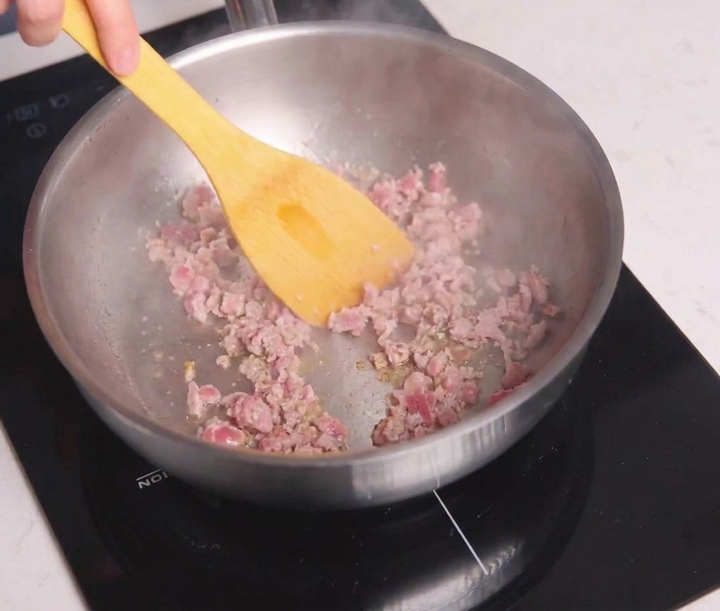 Viande hachée en train dêtre dorée dans une poêle avec une spatule jaune jusquà obtenir une belle coloration.