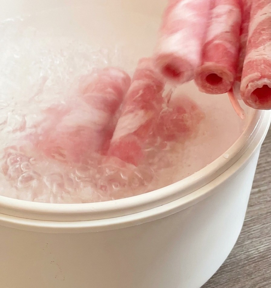 Tranches de bœuf congelées plongées dans une casserole deau bouillante pour un blanchiment rapide.