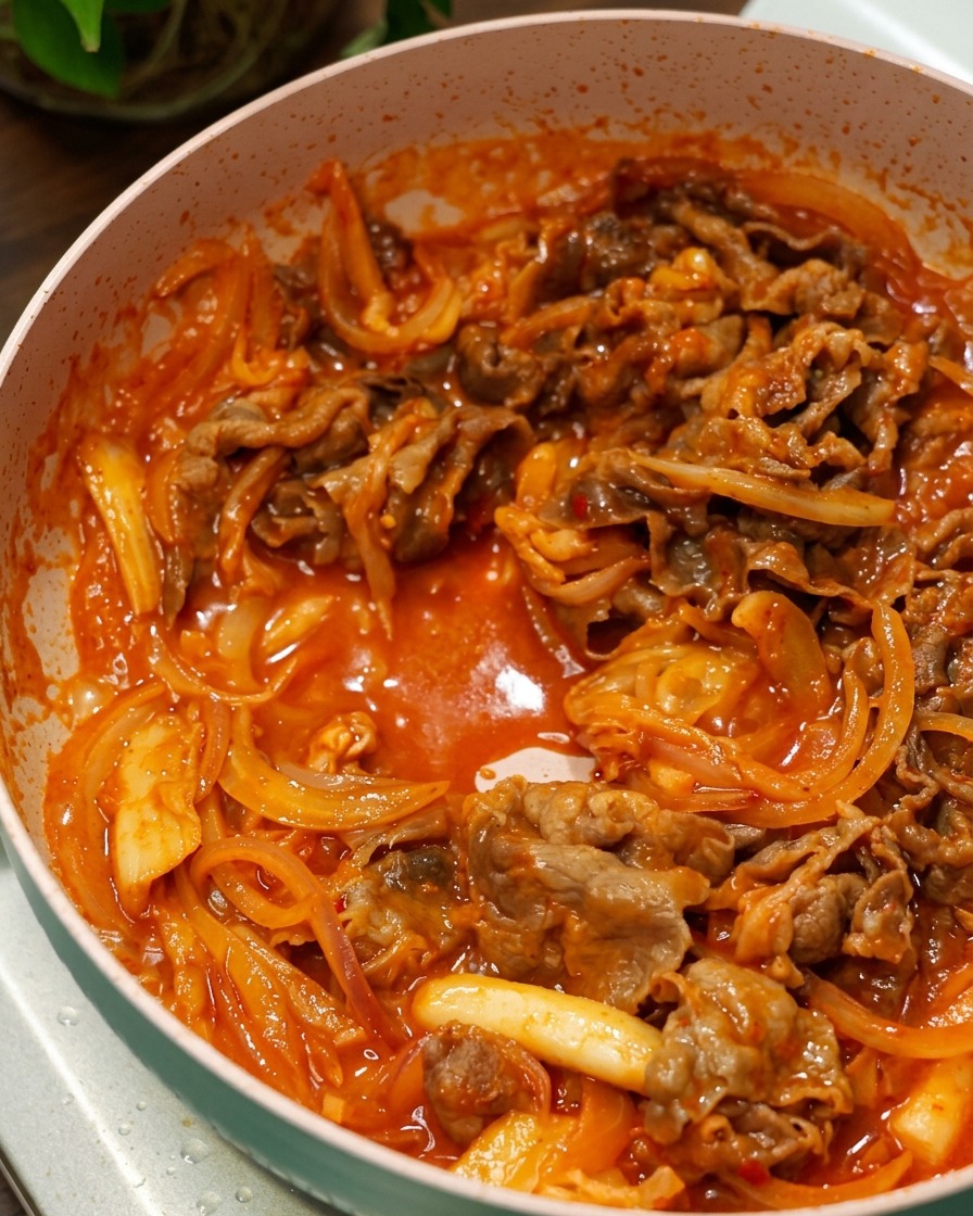 Bœuf et oignons frémissant dans une sauce pimentée coréenne épaisse et rouge.