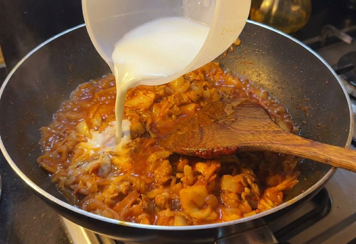 Eau amylacée laiteuse versée dans la poêle de bœuf et kimchi pour lier la sauce rouge.