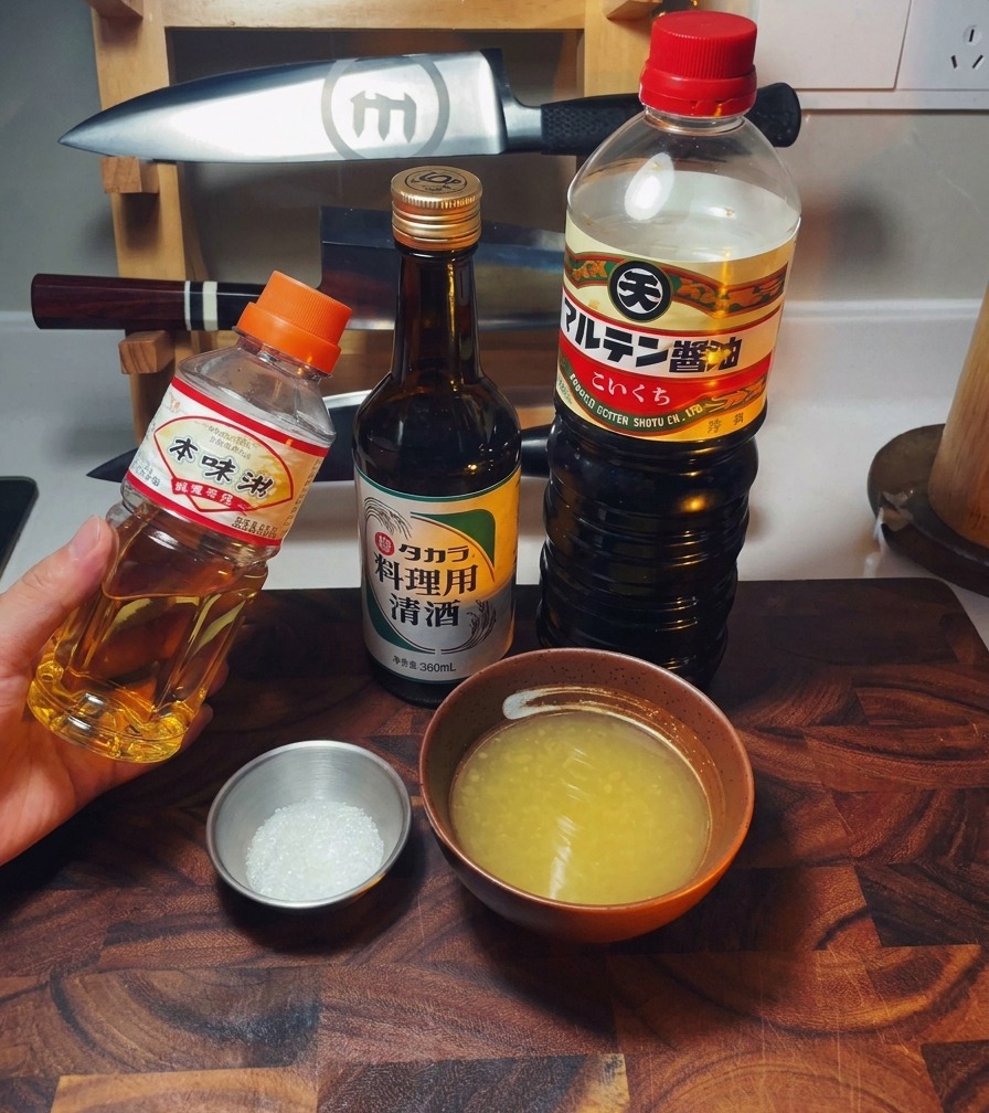 Bouteilles de mirin, saké et sauce soja à côté dun bol de bouillon de poulet et de sucre.