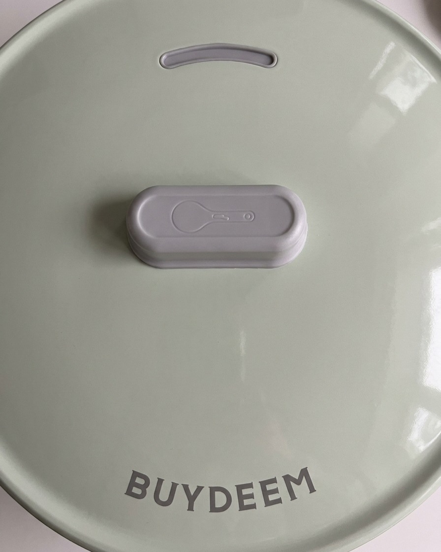 Le couvercle vert clair dun cuiseur à riz moderne refermé pour commencer la cuisson.