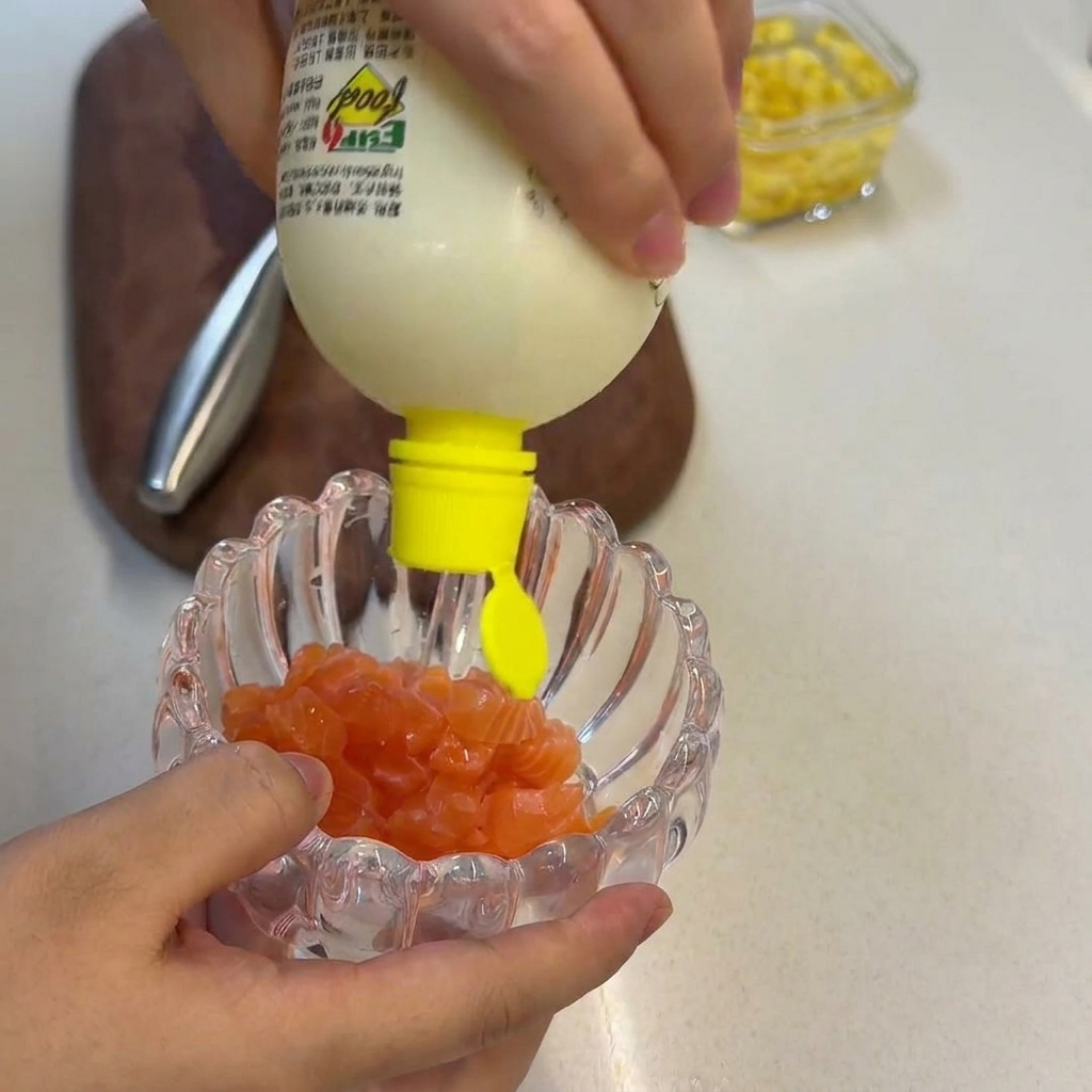 Jus de citron frais pressé sur des cubes de saumon cru dans un bol en verre.