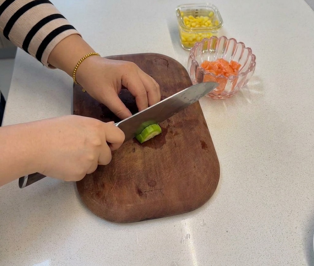 Une main coupant une tige de brocoli pour créer de petites fleurs de taille égale.