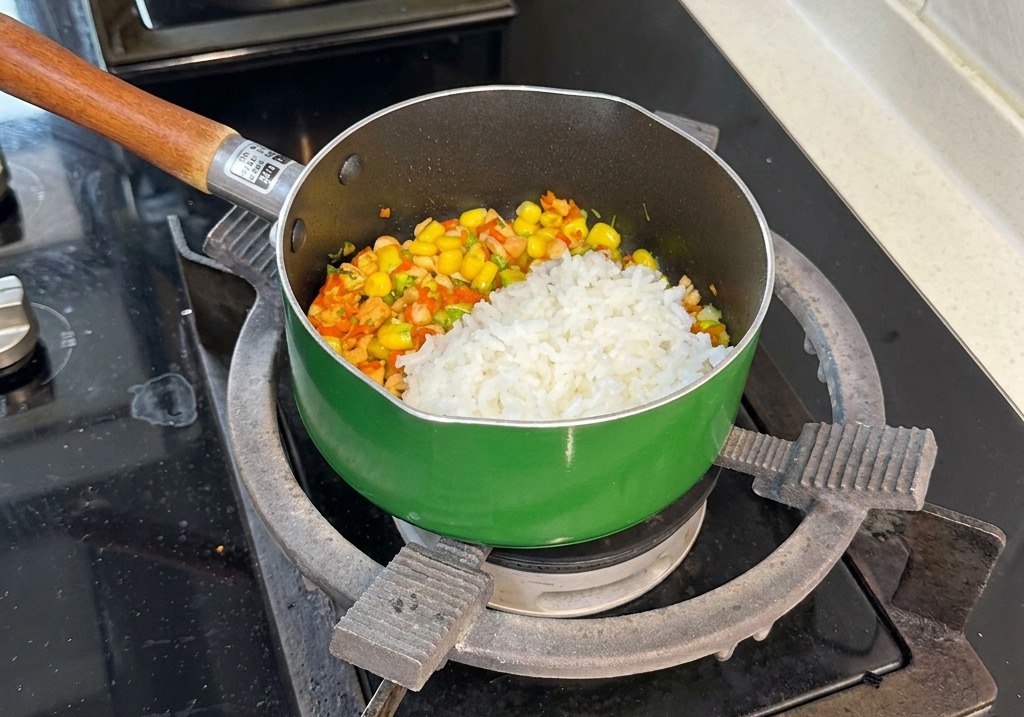 Une portion de riz blanc sur le mélange coloré de saumon et légumes dans la poêle.
