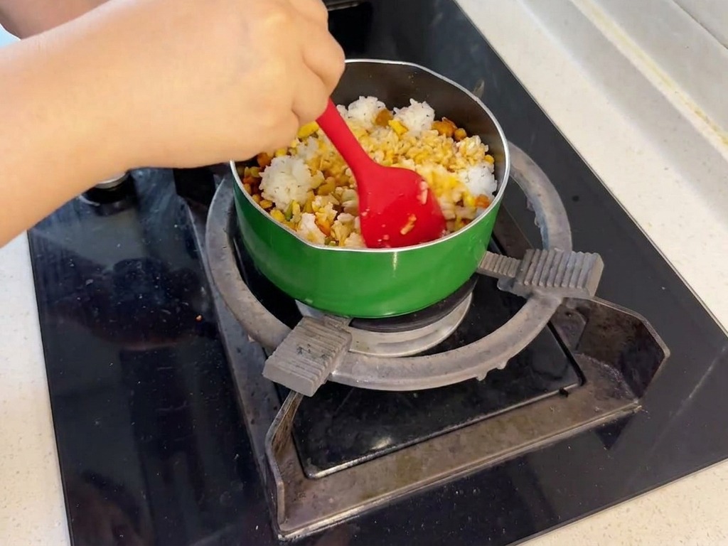 Une personne mélangeant le riz blanc avec le saumon et les légumes à laide dune spatule rouge.