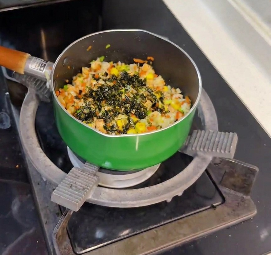 Flocons dalgues vertes saupoudrés sur le riz au saumon fraîchement préparé.