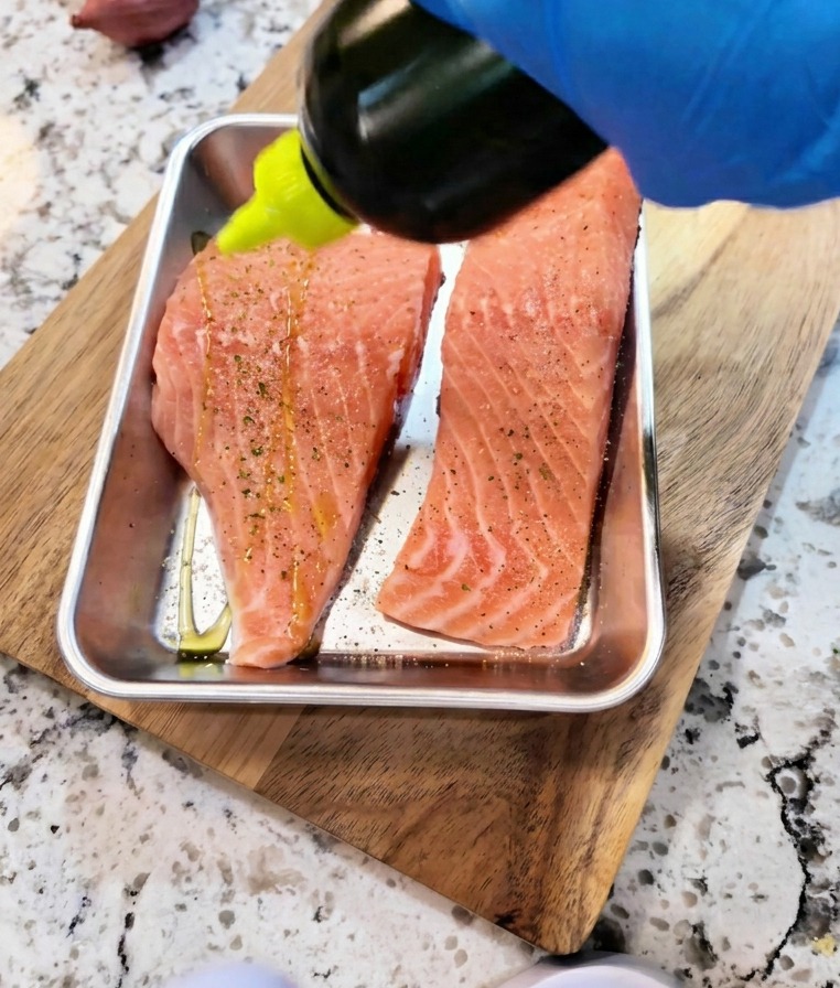 Sauce soja et huile versées sur des filets de saumon crus assaisonnés pour la marinade.