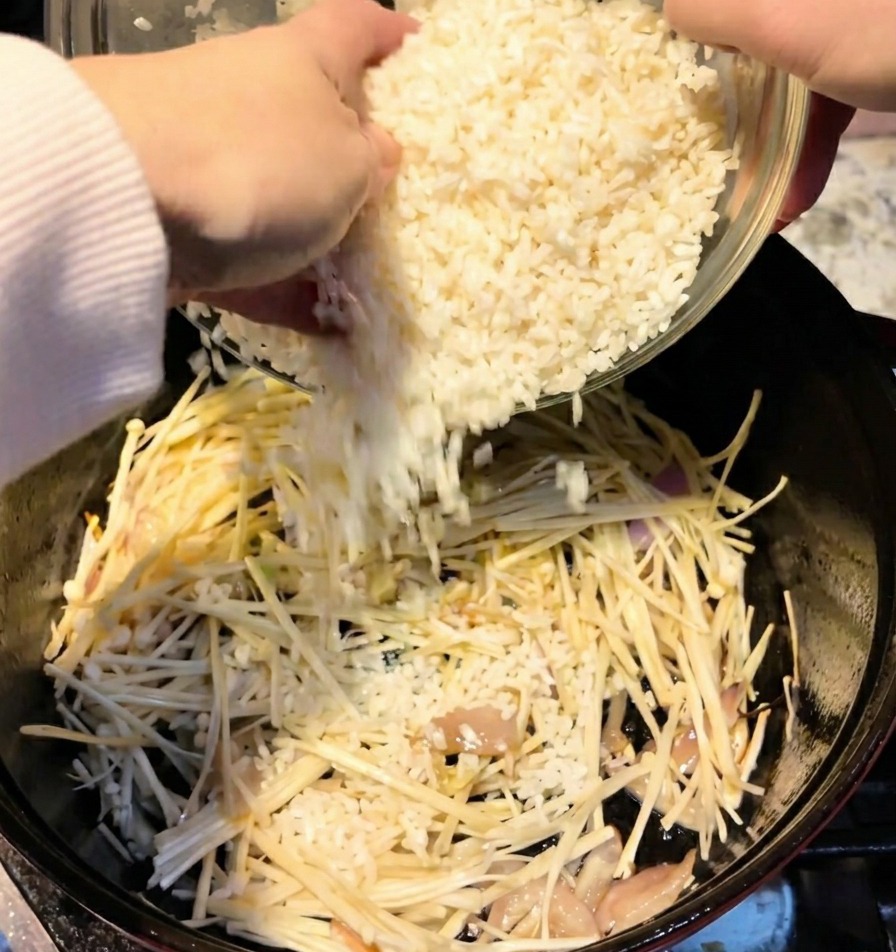 Deux tasses de riz blanc versées dun bol dans une cocotte contenant les champignons.