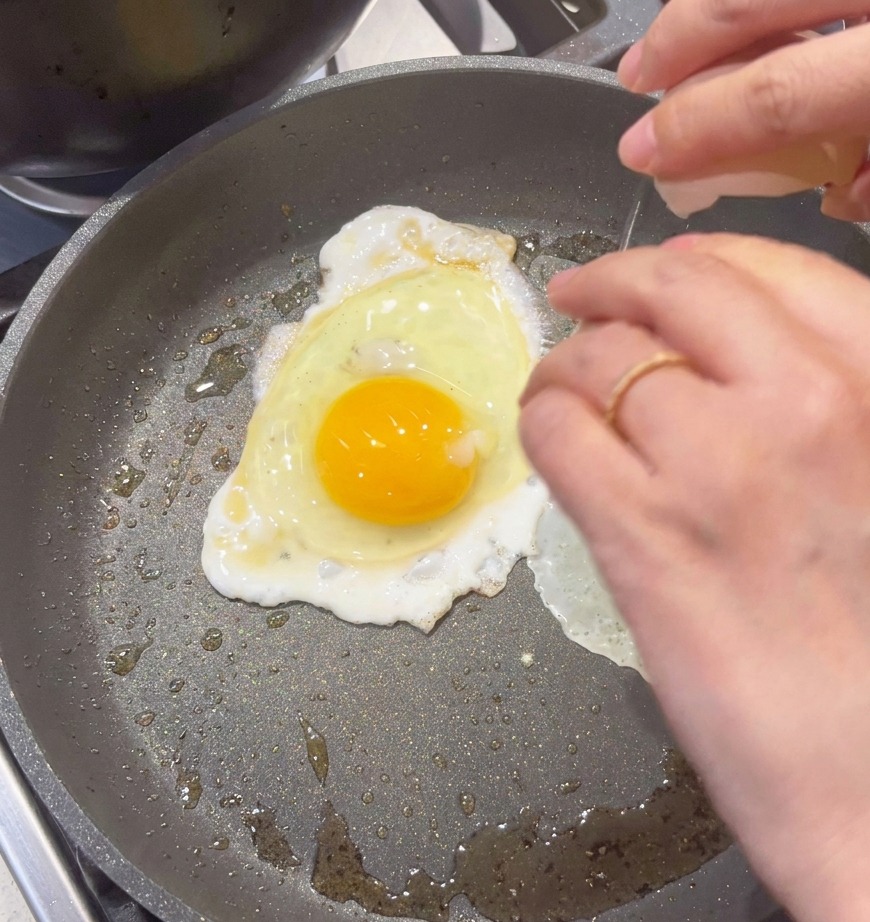 Un œuf cassé dans la poêle pour être brouillé.