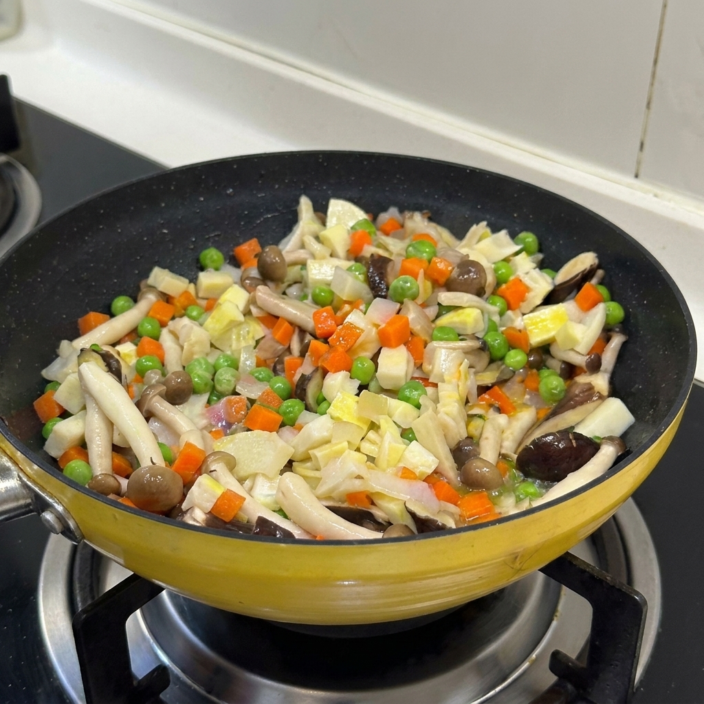 Mélange coloré de légumes et de champignons sautés ensemble dans une poêle jaune.