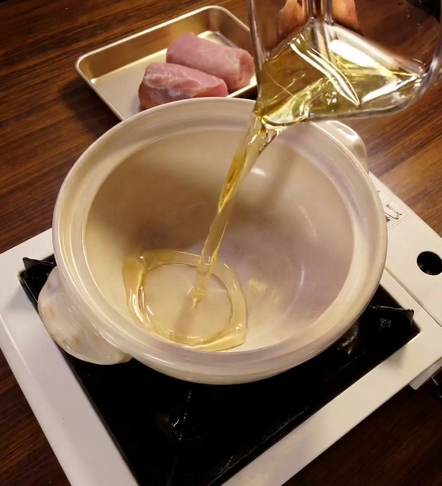Verser le mirin dans une petite casserole en céramique blanche sur un réchaud