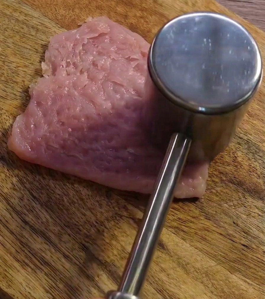 Attendrisseur à viande frappant la tranche de porc pour laplatir