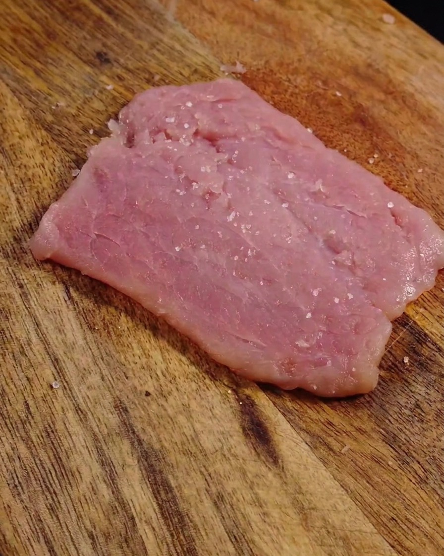 Grains de sel et de poivre sur la surface de la viande aplatie