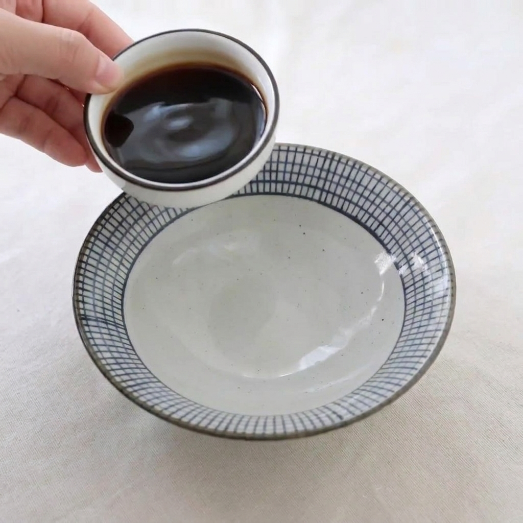 Versage de sauces brunes et de miel dans un bol en céramique pour préparer la sauce de laquage.