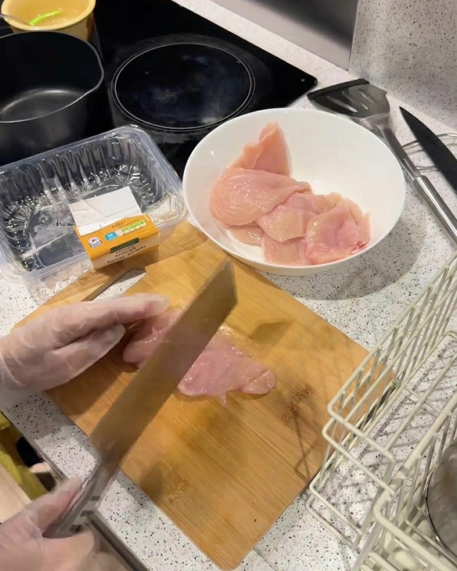 Le dos dun couteau lourd frappant un filet de poulet pour laplatir et lattendrir sur une planche en bois.
