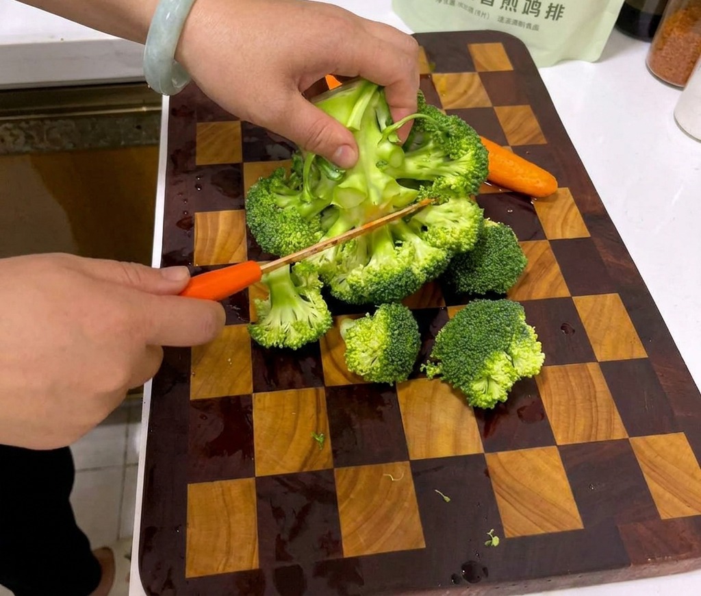 Mains découpant une tête de brocoli frais en petits bouquets sur une planche à découper en bois.