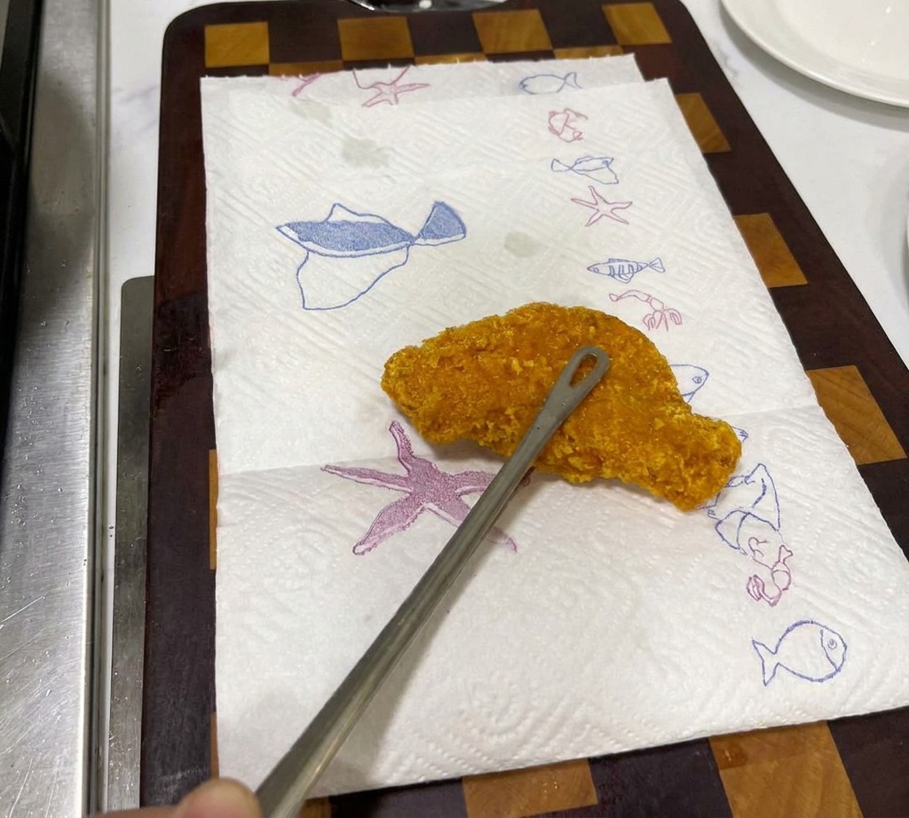 Steak de poulet katsu croustillant reposant sur une assiette tapissée de papier absorbant pour éponger lhuile.
