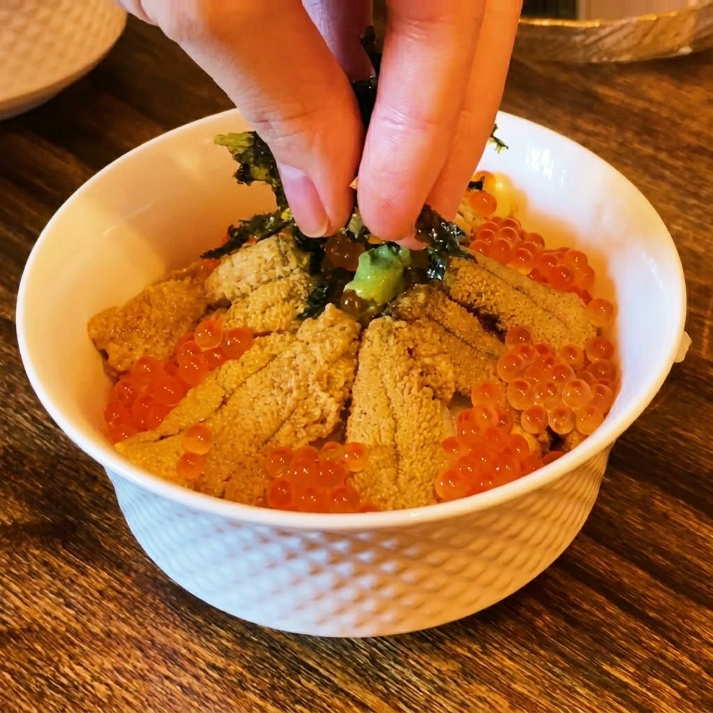 Des doigts saupoudrant des algues séchées en lamelles sur le dessus dun bol de sushi garni doursin et dœufs de saumon.