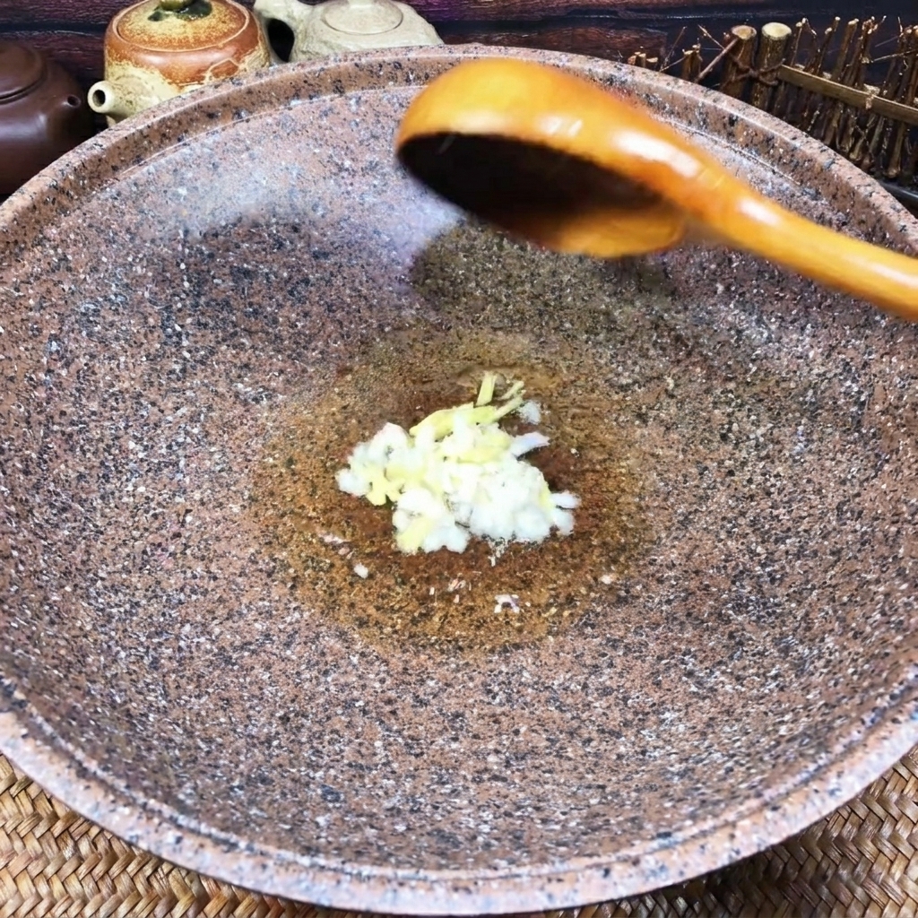 Ail et gingembre hachés frémissant dans un fond dhuile dans un wok.