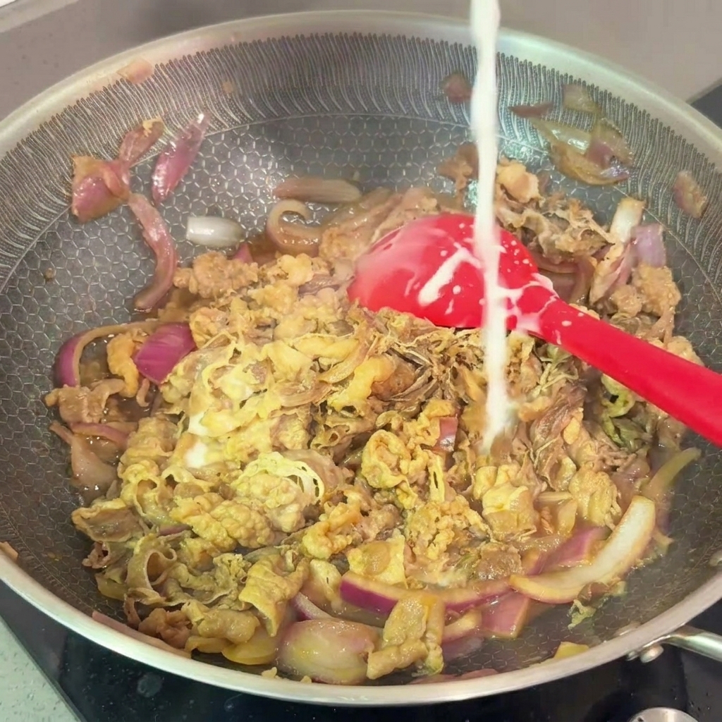 Versement dun filet de mélange de fécule et deau dans la poêle de bœuf frémissante.
