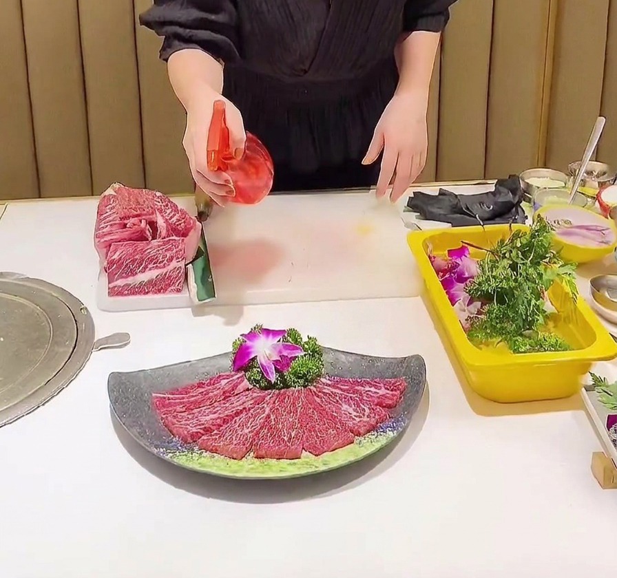 Un vaporisateur rouge diffusant un assaisonnement liquide sur une assiette de bœuf persillé finement tranché.