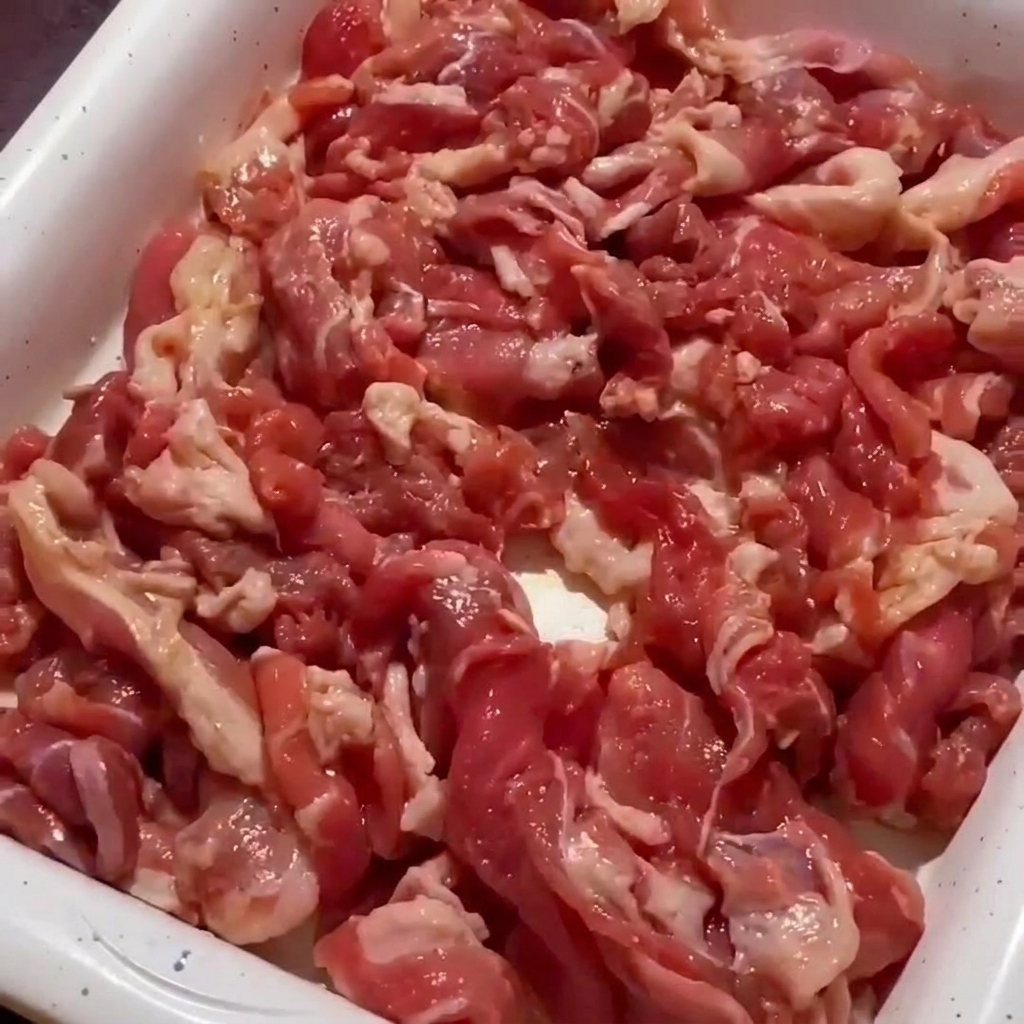 Gros plan sur le porc sautant dans la poêle, commençant à dorer sur les bords.