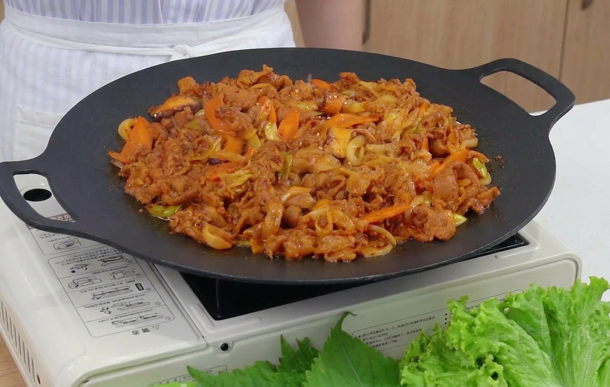 Graines de sésame saupoudrées sur le porc sauté fumant.