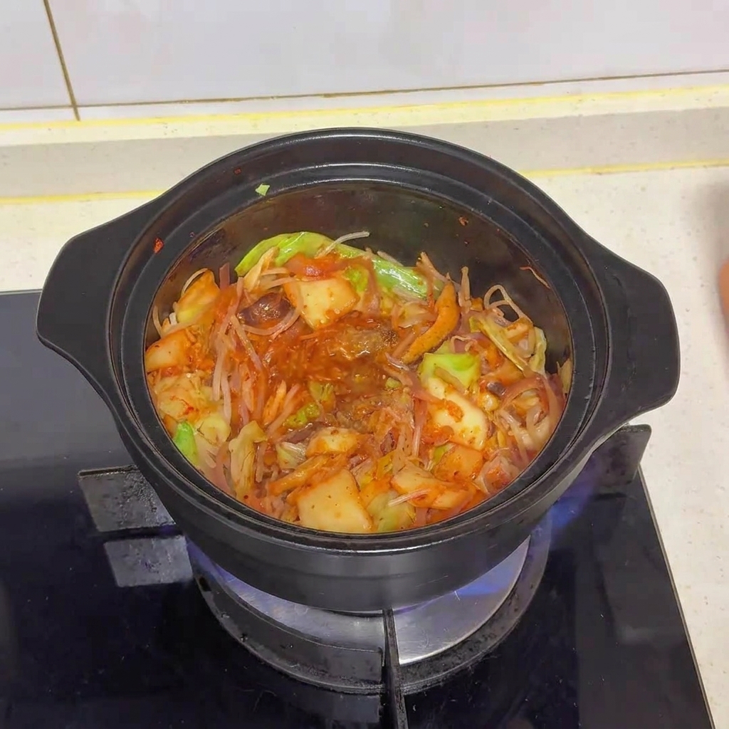 Le mélange de légumes et de kimchi dans la marmite après lajout de la poudre et du MSG.