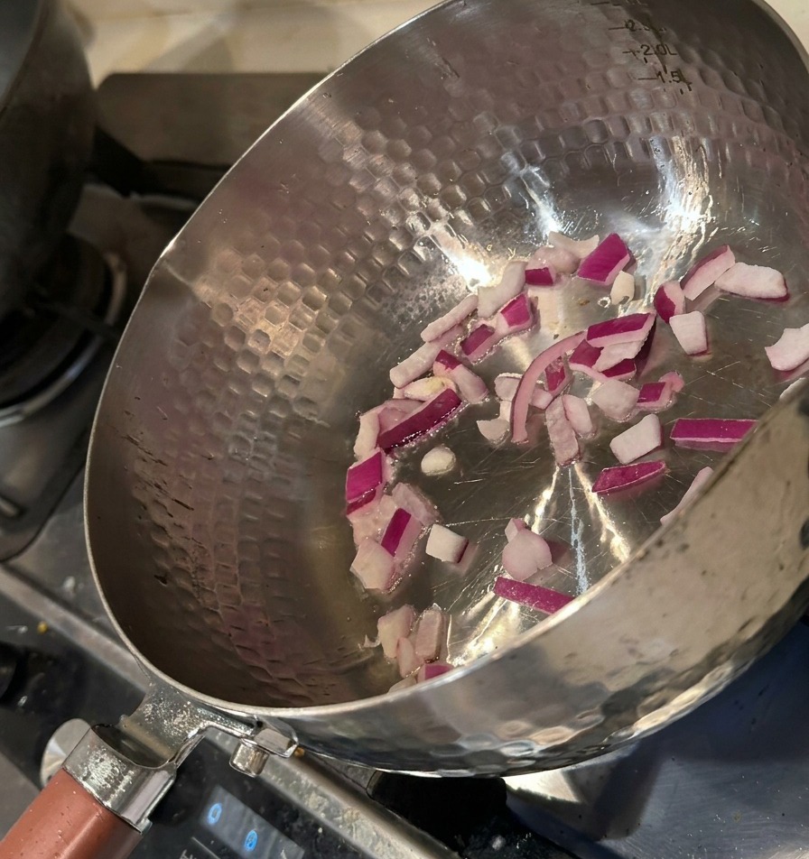 Oignons rouges hachés sautant dans une marmite chaude avec un léger filet dhuile.