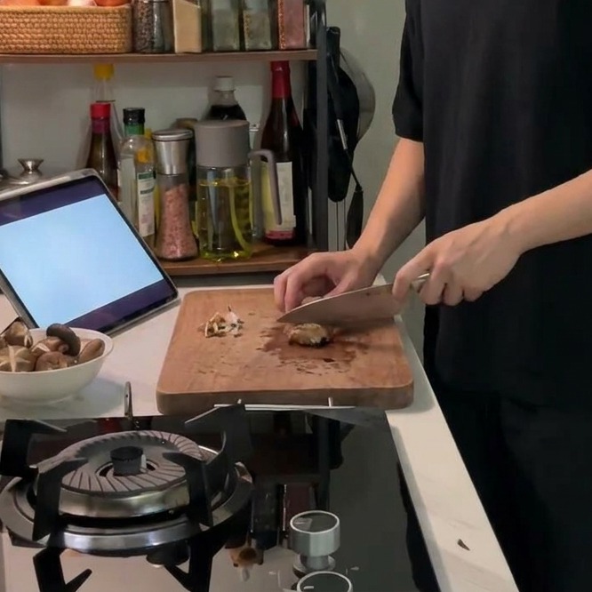 Un couteau de cuisine traçant une croix décorative sur le dessus dun chapeau de champignon shiitake brun.