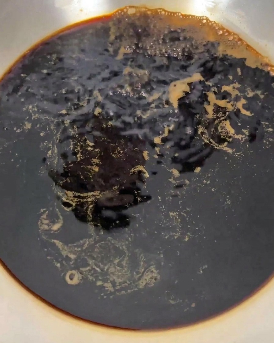 Le mélange de sauce soja et dalcool bouillonnant vigoureusement dans une casserole sur la cuisinière.