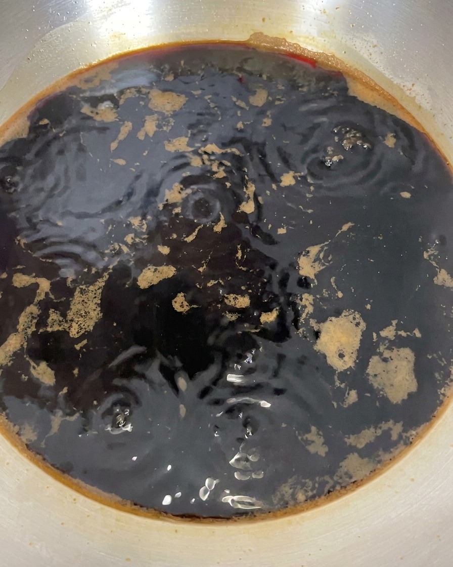 Mélange sombre dans la casserole après larrêt du feu montrant de légères bulles résiduelles.