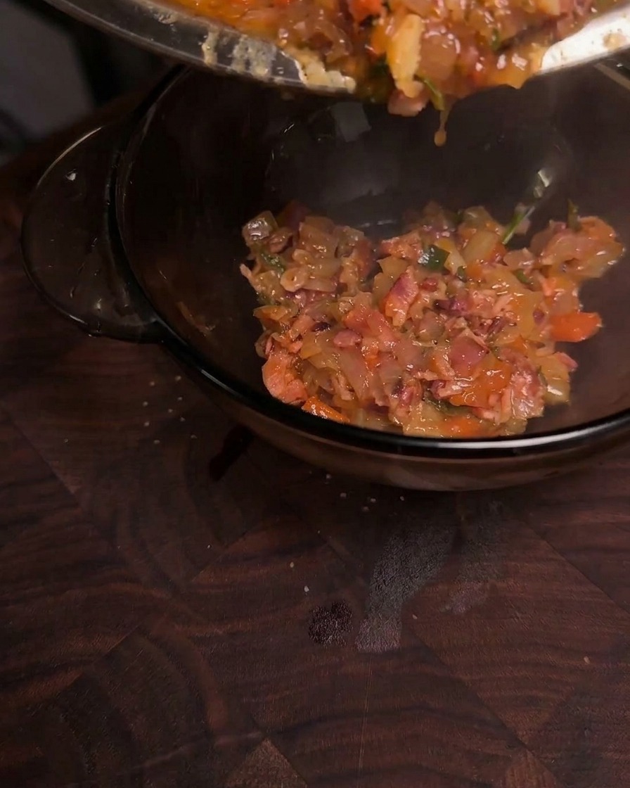 Confiture de bacon caramélisée, épaisse et brillante, versée dune poêle dans un bol en verre transparent.