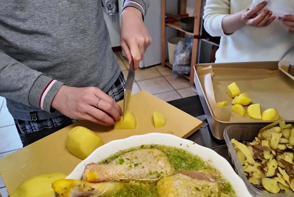 Découpe de pommes de terre crues épluchées en morceaux de taille régulière sur une planche à découper avec un couteau de cuisine bien aiguisé.