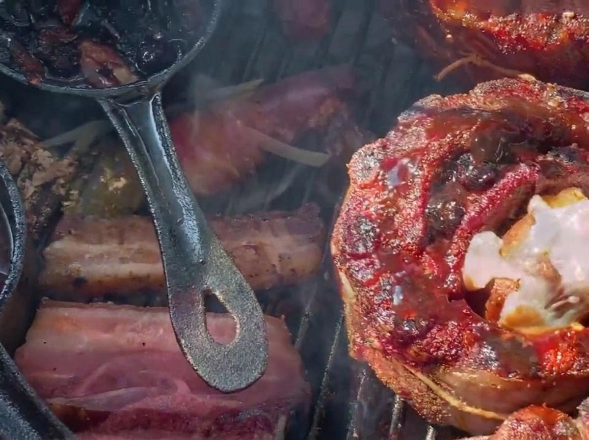 Du fromage râpé fondant sur un panier de ribs farci et glacé aux myrtilles sur un barbecue au charbon.