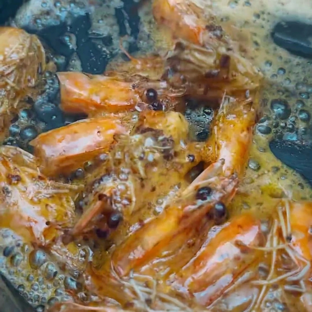 Têtes de crevettes retirées de lhuile parfumée avec des baguettes.