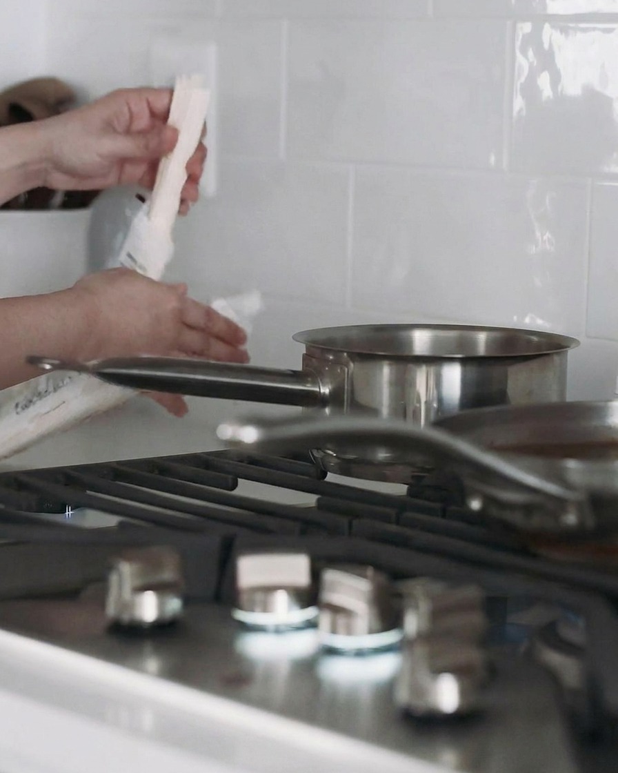 Une casserole deau sur la cuisinière avec des nouilles udon en train de cuire à lintérieur.