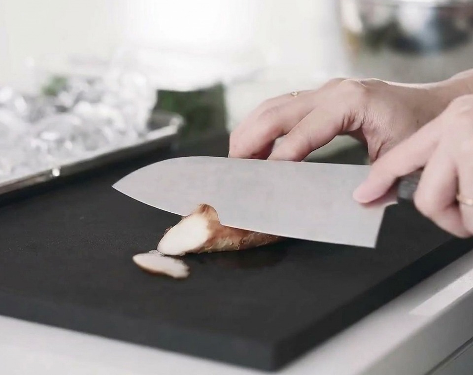 Tranches de blanc de poulet cuit disposées sur une planche à découper.