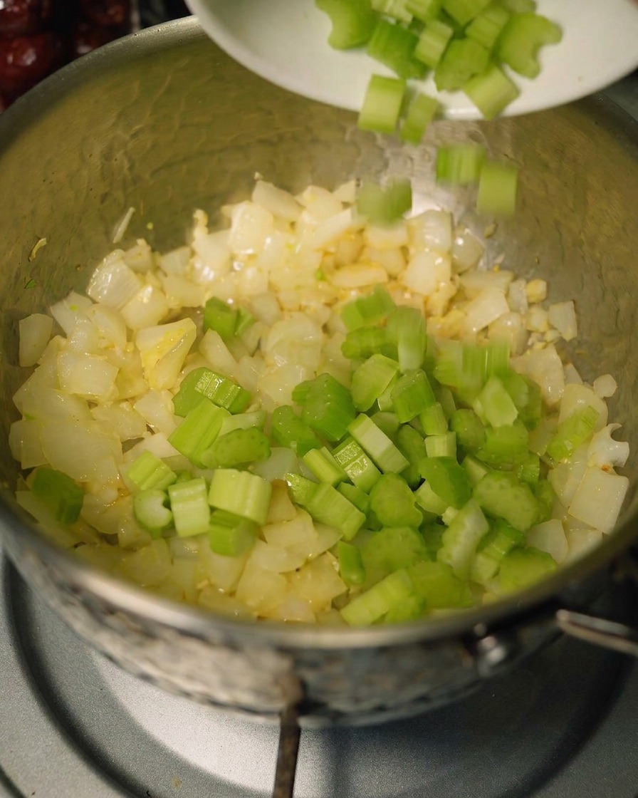 Céleri et carottes ajoutés dans la casserole avec les aromates.