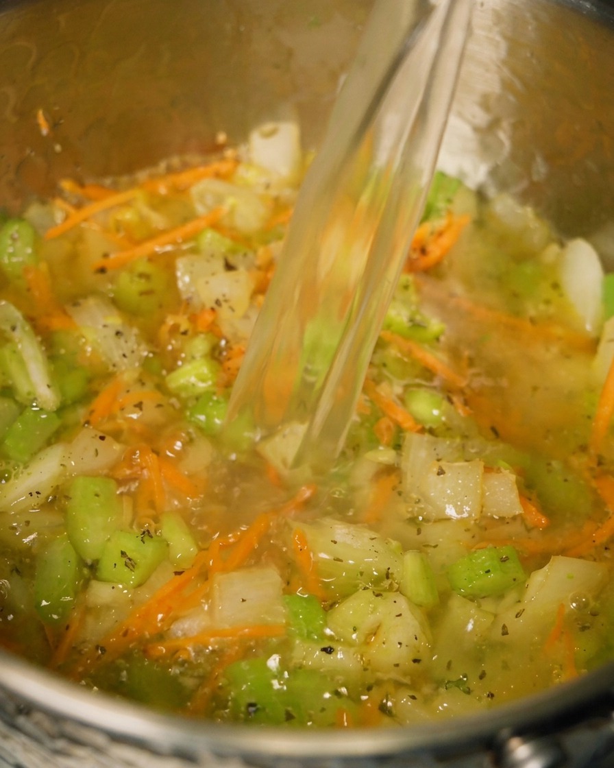 Bouillon de poulet versé dans la casserole.