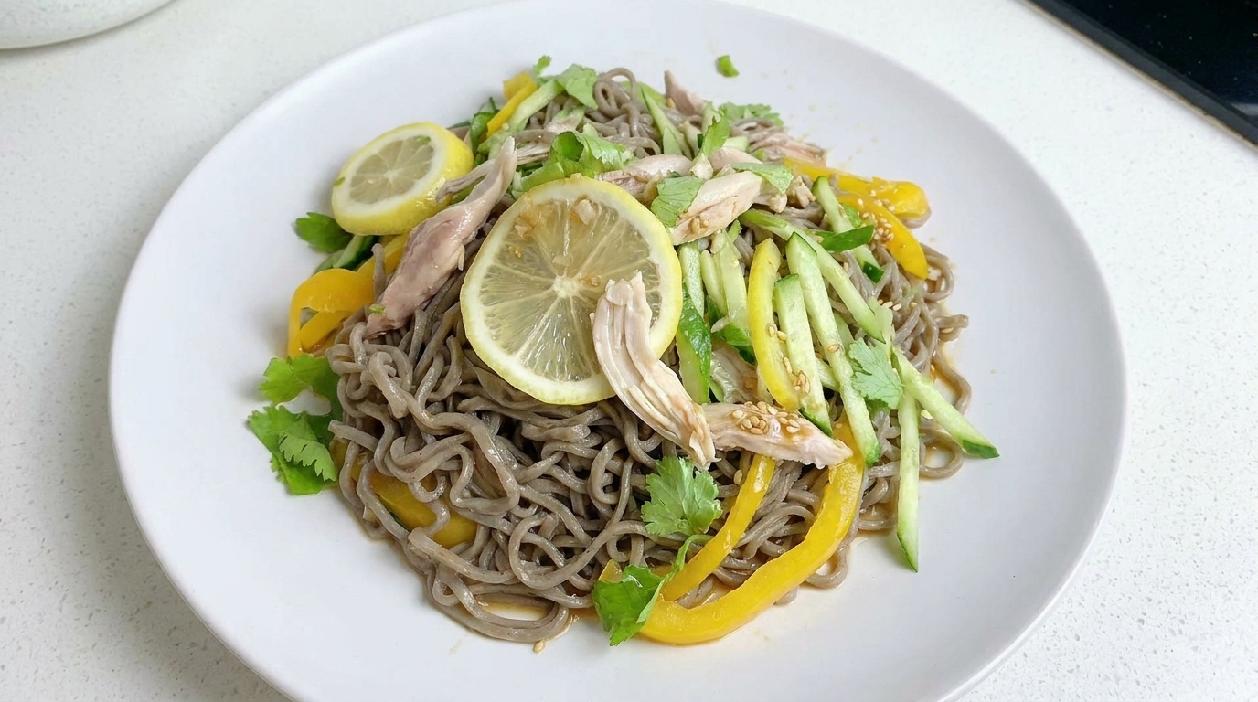 Une salade de nouilles au sarrasin zestée, garnie de poulet effiloché, de légumes frais en julienne et de fines tranches de citron.