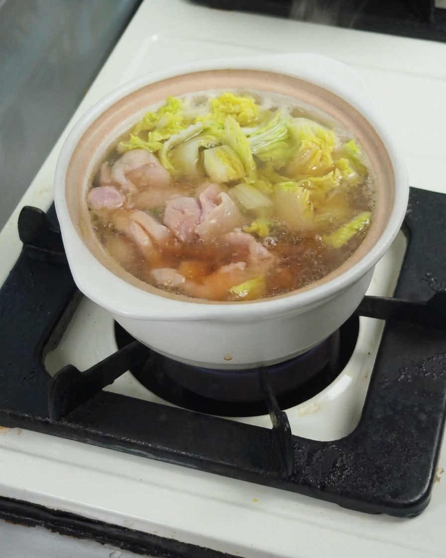Sauce soja versée dans le bouillon frémissant pour assaisonner le mélange.