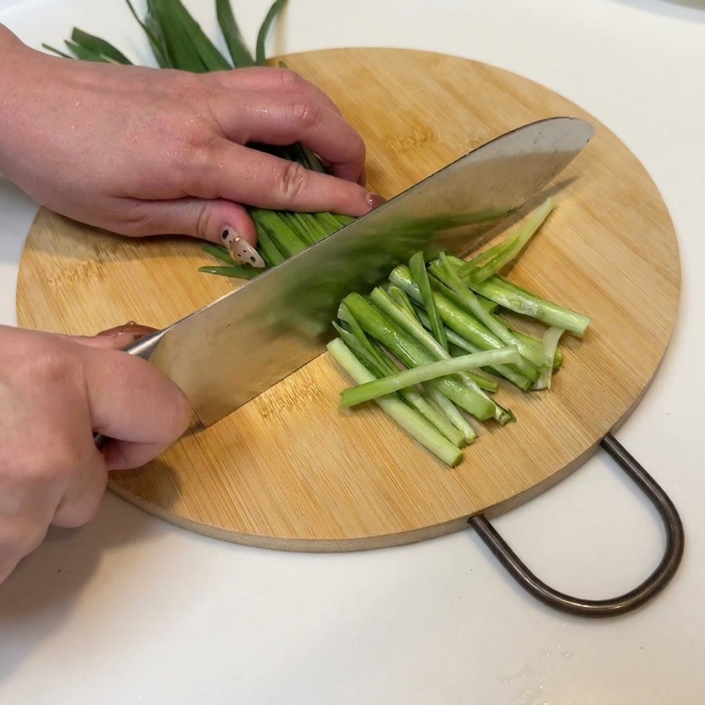 Oignons verts et ciboulette proprement tranchés et prêts pour la poêle.