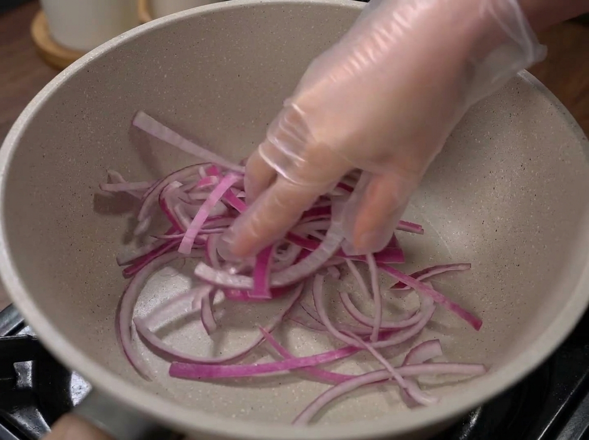 Oignons et chou disposés au fond dun pot de cuisson vide.