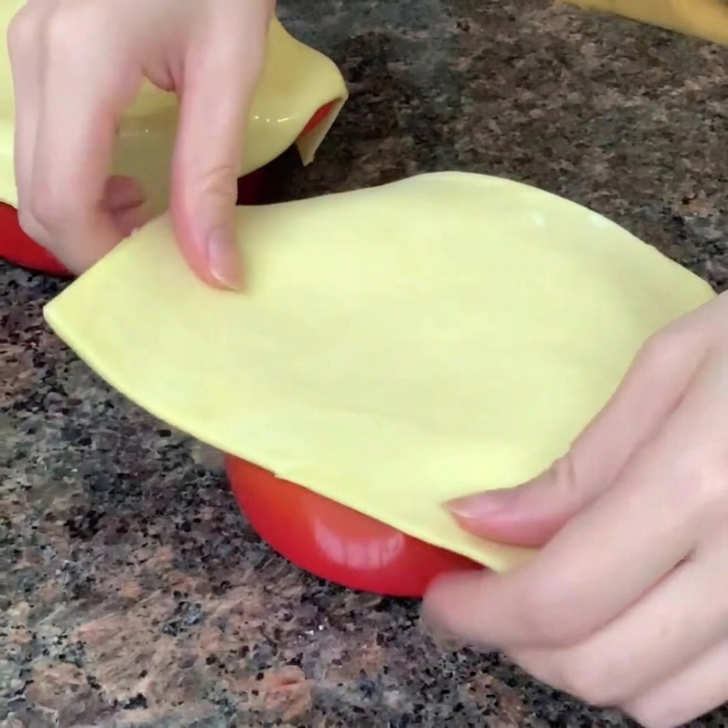 Une feuille de pâte feuilletée posée et scellée sur le bord dun bol contenant la chaudrée.